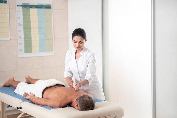 Мужчина делает терапевтический массаж в больнице
