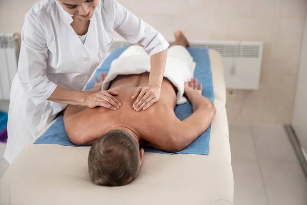 Lycklig kvinnlig läkare gör massage för patienten — Stockfoto