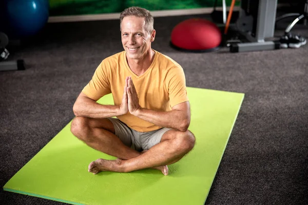 Mutlu adam nilüfer pozisyonunda oturuyor.