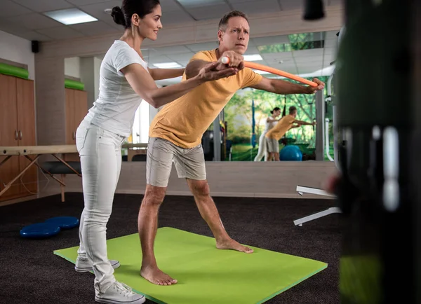 Erkek olgun hasta germe egzersizleri yapıyor