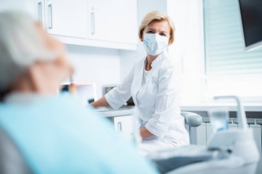 Doctr ve hasta birbirlerine bakıyorlar.