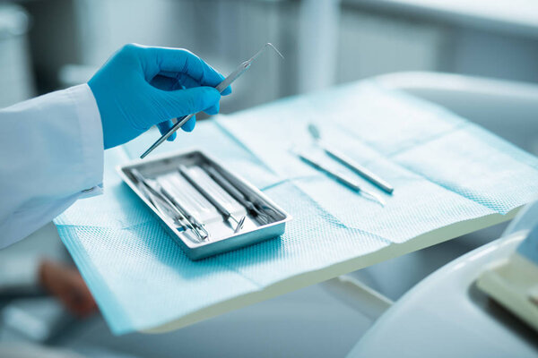 Dentist working with surgical instruments in office