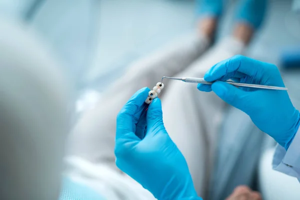 Dentysta trzyma instrument dentystyczny w klinice — Zdjęcie stockowe