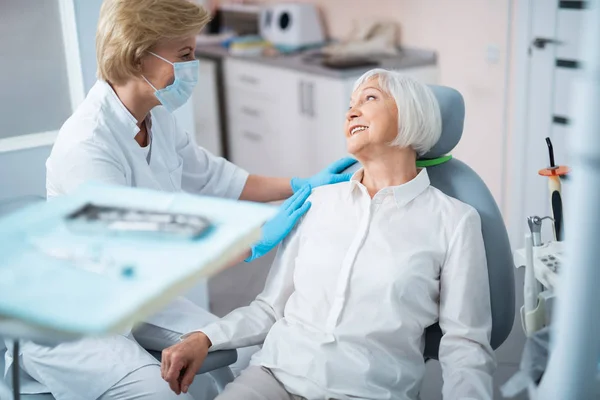 Dentista está tendo uma discussão amigável com paciente — Fotografia de Stock