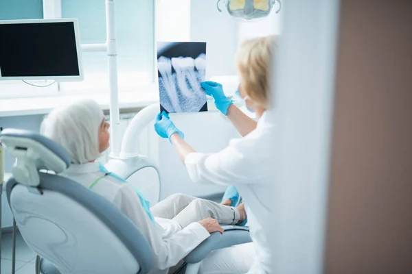 Kvinnlig läkare håller tandröntgen i Office — Stockfoto