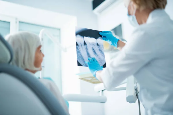 Doutor em luvas estéreis segurando um raio-x — Fotografia de Stock