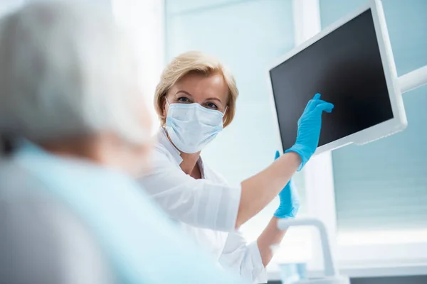 Dentista apontando um dedo para a tela do monitor — Fotografia de Stock