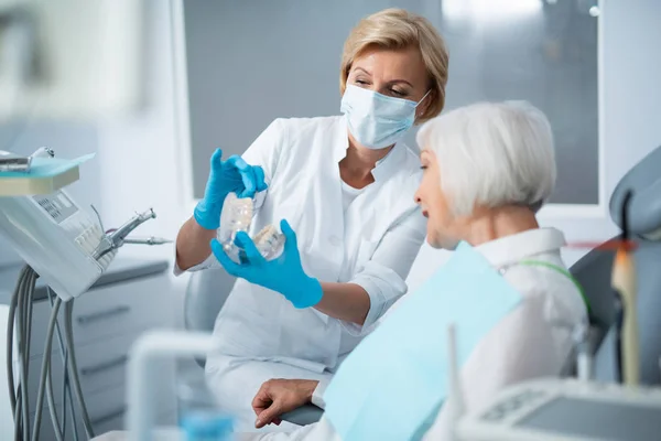 Dentista feminina e senhora adulta em um consultório de dentista — Fotografia de Stock