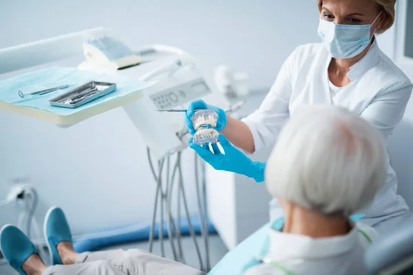 Dentista feminina com senhora adulta na clínica odontológica — Fotografia de Stock