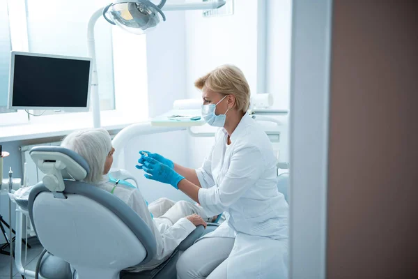 Estomatologista profissional verificando dentes de senhora adulta — Fotografia de Stock