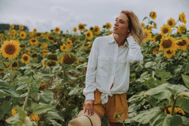 Genç güzel kadın ayçiçeği alanında dinlenme zevk