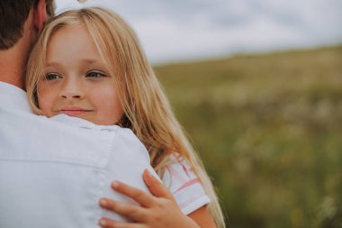 Güzel küçük kız babasına sarılıyor.