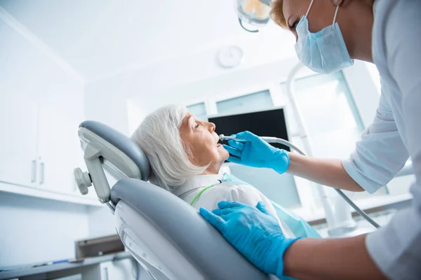 Dentista está usando instrumentos dentários durante o procedimento — Fotografia de Stock