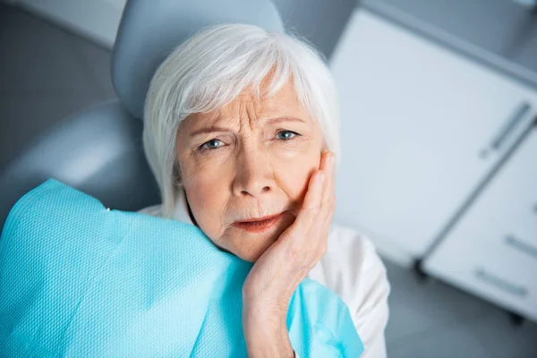 Klinikte diş ağrısı olan üzgün yetişkin kadın — Stok fotoğraf