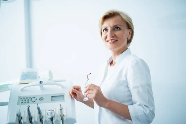 Dentista feminina está olhando para longe no escritório — Fotografia de Stock