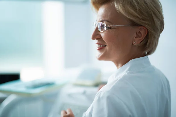 Счастливая женщина врач в очках в клинике — стоковое фото