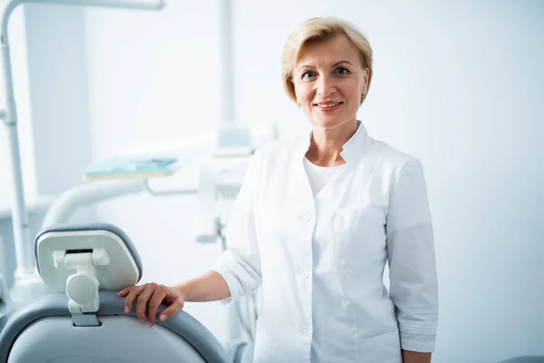 Dentista feminina está posando no consultório odontológico — Fotografia de Stock