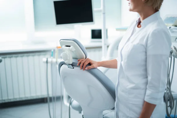 Médica feminina está de pé perto da cadeira dentária — Fotografia de Stock