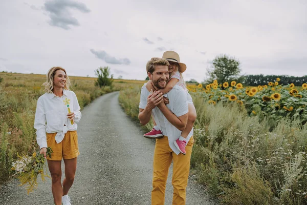 Petite fille passe du temps avec ses parents près du champ — Photo