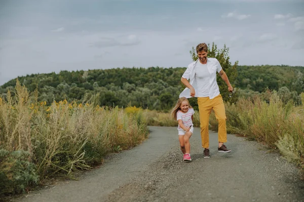 Pequeña chica caucásica divertirse con el padre en la carretera al aire libre —  Fotos de Stock