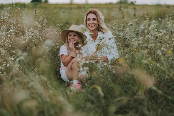 Красива мати сміється зі своєю маленькою дочкою в полі — стокове фото
