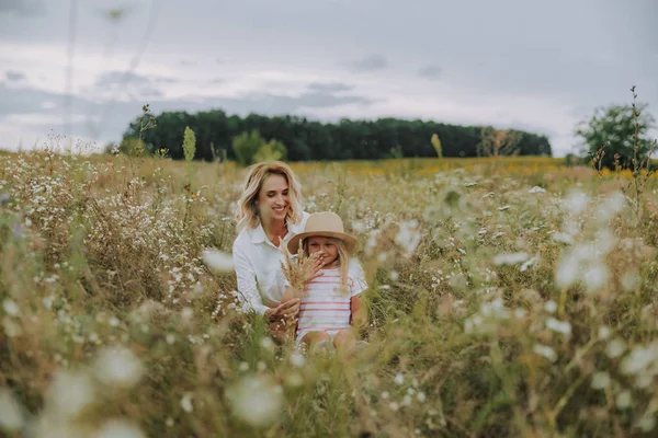 Affascinante signora abbracciando la sua piccola figlia in campo — Foto Stock