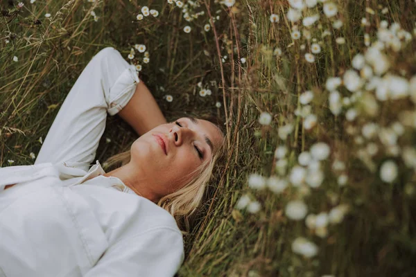 Flot ung dame sover i græs - Stock-foto