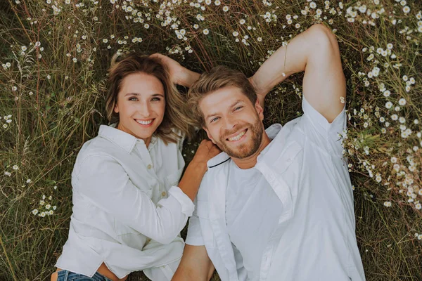 Homme et femme souriants sur l'herbe à l'extérieur — Photo