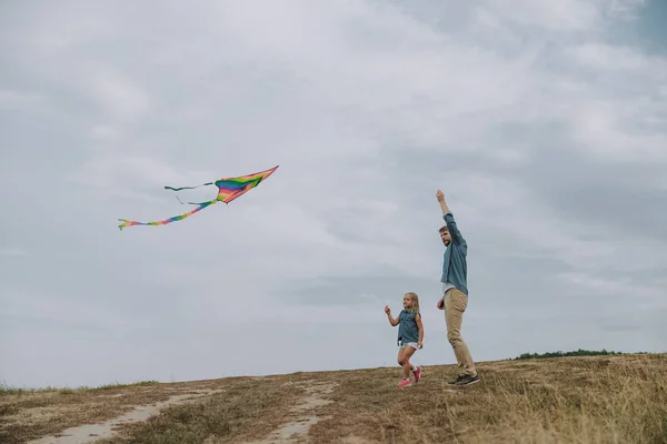 Vader en dochter met een vlieger buitenshuis — Stockfoto
