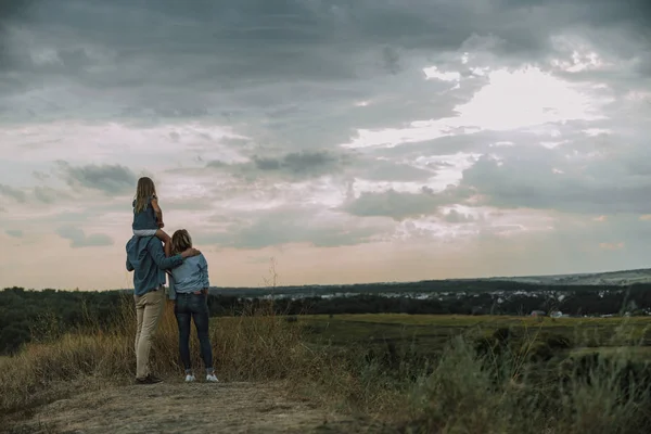 Jeune famille regarde loin sur la colline — Photo