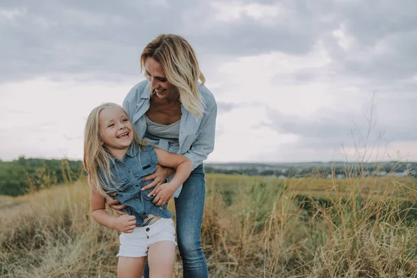 Sorridente madre sta giocando con la piccola figlia — Foto Stock