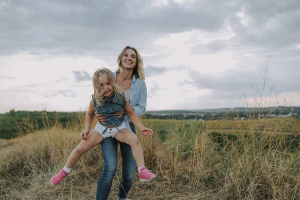 Madre felice sta crescendo figlia su mani — Foto Stock