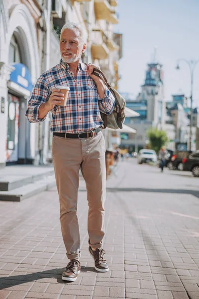 Зрелый мужчина наслаждается кофе на уличной фотографии — стоковое фото