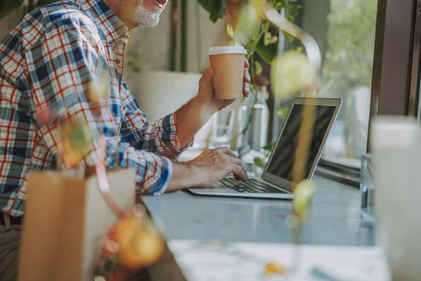 Man med kartong kopp kaffe och laptop Stock Foto — Stockfoto