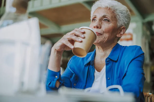 Продумана жінка сидить з чашкою кави фото — стокове фото