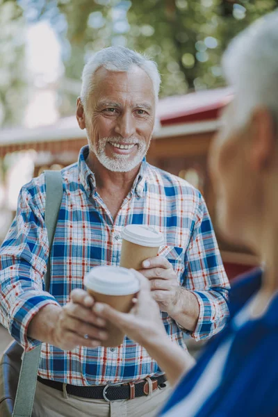 Улыбающийся взрослый мужчина предлагает кофе, чтобы пойти фото — стоковое фото