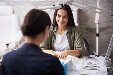 Manikürcü ile sohbet ederken tırnak banyosunda kol ıslatan çekici genç bayan