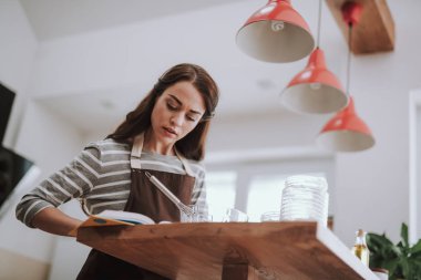 Genç bayan evde tarife göre yemek yapıyor