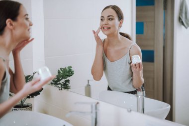 Neşeli güzel kadın aynaya bakıyor