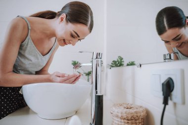 Sabah yüzünü yıkayan sevinçli güzel kadın