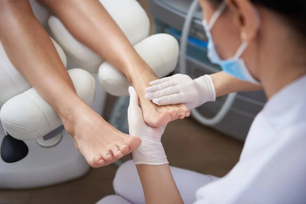 Pedicurist delikatnie masując kobietę nogę po pedicure — Zdjęcie stockowe