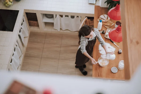 Mujer está hablando por teléfono mientras cocina en casa —  Fotos de Stock