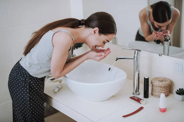 Neşeli genç kadın sabah yüzünü yıkadı — Stok fotoğraf