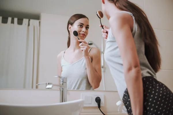 Low angle of an attractive woman taking care of her face — Stock Photo, Image