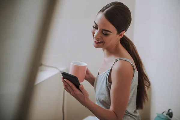 Örülök, szép nő használ neki okostelefon örömmel — Stock Fotó