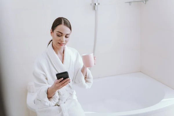 Красива молода жінка насолоджується кавою у ванній — стокове фото