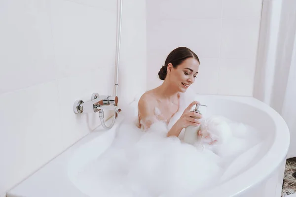 快乐的年轻女子在浴室应用沐浴露 — 图库照片