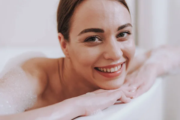 Primer plano de una mujer encantada sonriendo en el baño —  Fotos de Stock