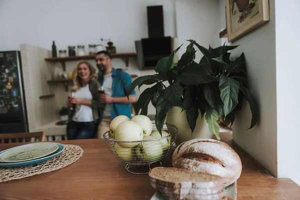 Pan fresco y manzanas ubicadas en la mesa de la cocina en el acogedor apartamento —  Fotos de Stock