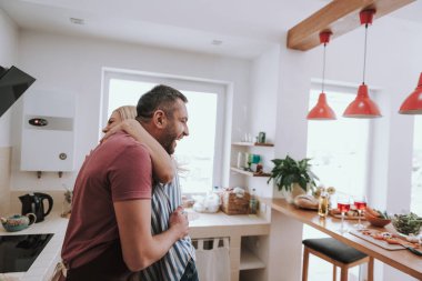 Mutlu sevgi dolu çift sarılma ve evde gülüyor